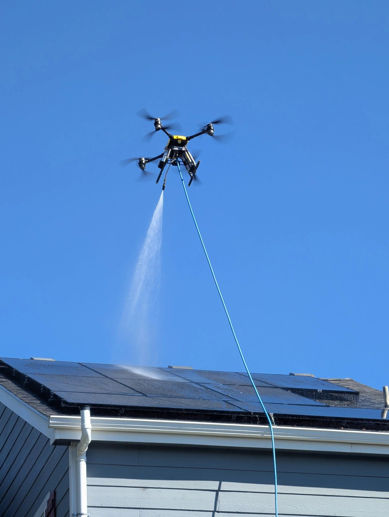 Drone rinsing rooftop solar panels